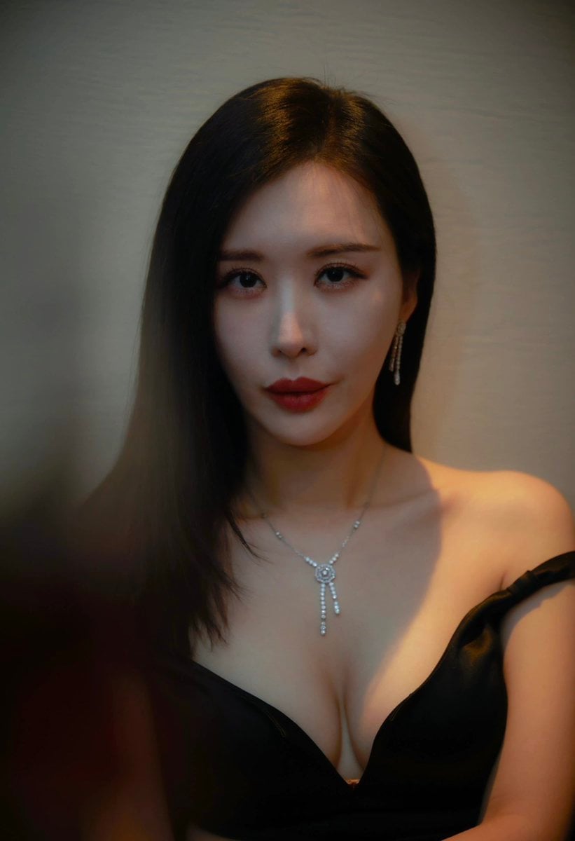A close-up portrait of a woman with dark, sleek hair and ... thumbnail 2