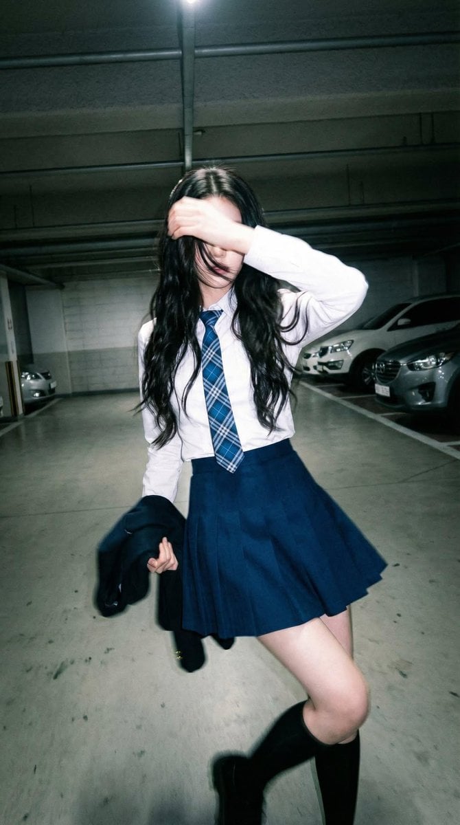 Candid portrait of a young woman in a dim parking garage,... thumbnail 2