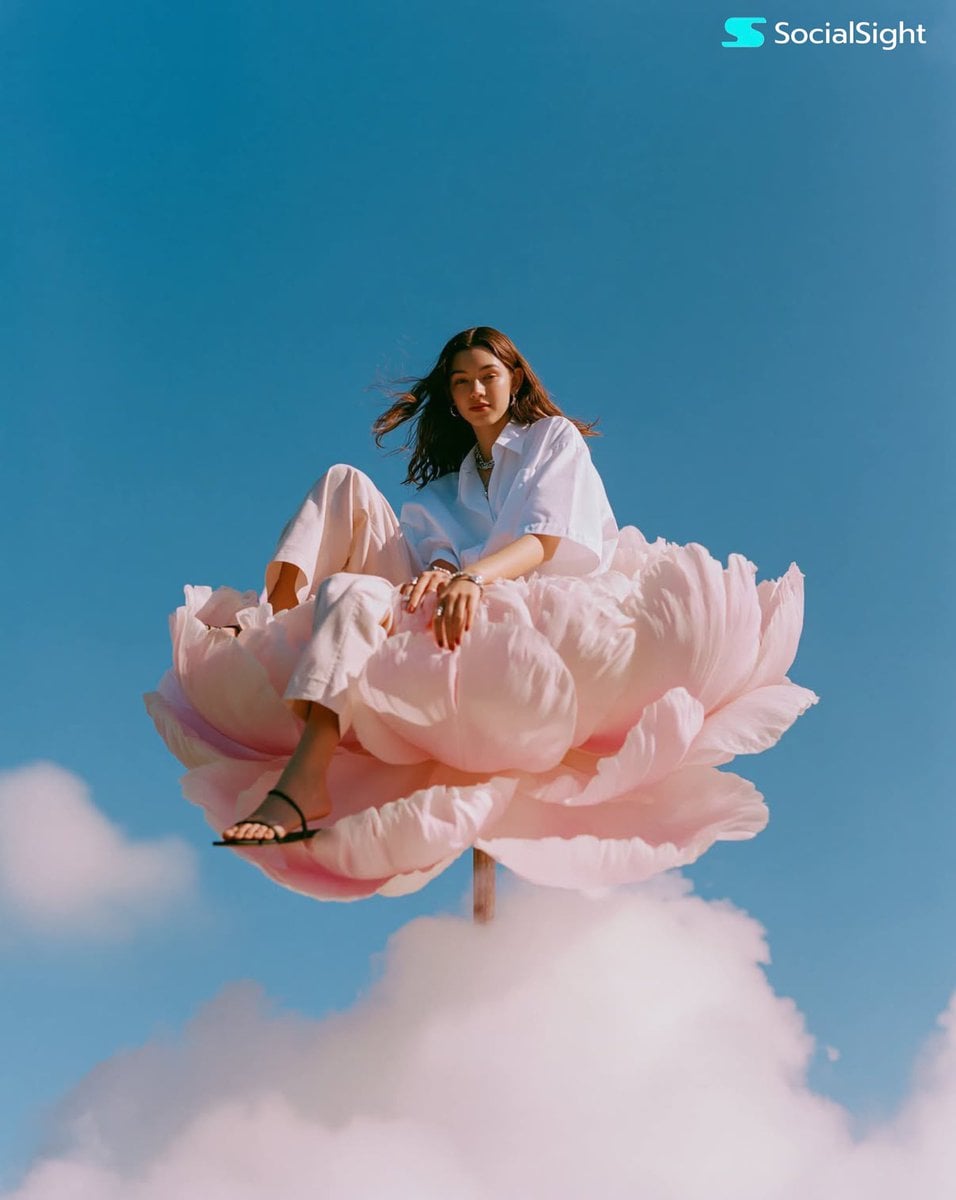 Model on a Giant Pink Flower Above the Clouds thumbnail 2